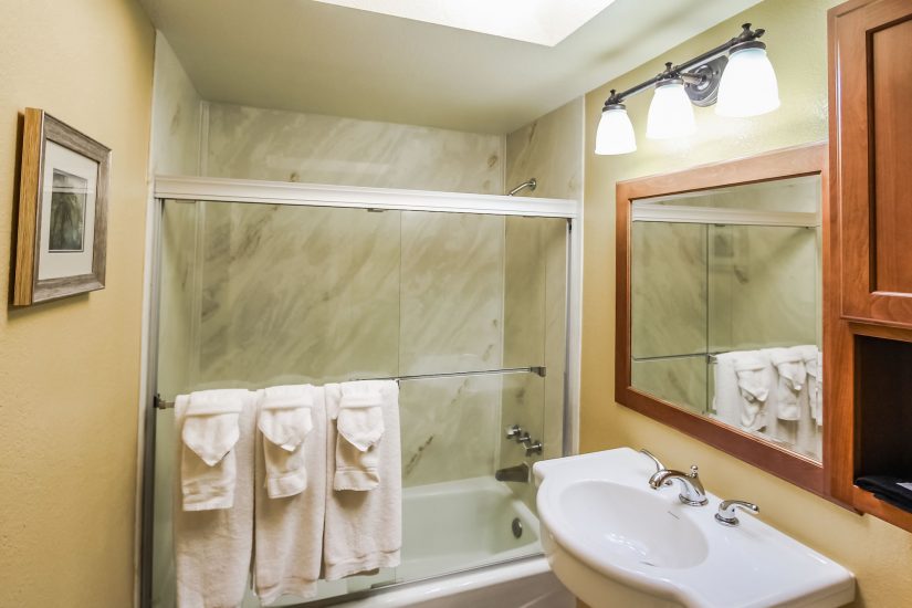 Photo of bathroom with white towels, bathtub and white sink